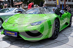 Green Lamboghini and Mercedes SLR parked on the pavement near each other in the street