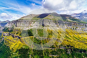 Green landscape with high mountains, green valleys, rocks and forests with blue sky and white clouds. Spanish Pyrenees, Ordesa