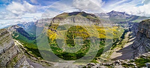 Green landscape with high mountains, green valleys, rocks and forests with blue sky and white clouds. Spanish Pyrenees, Ordesa