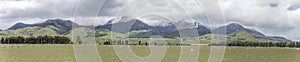 Green landscape with snow on Takitimu mountains, near The Key, New Zealand