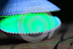 A green laser illuminates an open clam shell