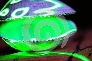 A green laser illuminates an open clam shell