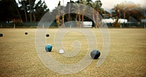 Green, lawn bowling and balls on grass, field or pitch in a match, game or competition of outdoor bowls. Ball, sport and