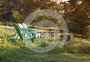 Green lawn chairs by a fire pit