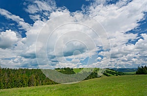 Green lawn on rural landscape with clouds on sky