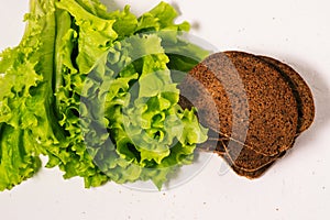 Green leafy salad and brown bread. Vegetarian healthy food. A top view of a flat layout
