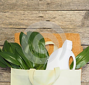 Green leaves in a bag with detergent on the background of bathing linen. Bioorganic washing product. Ecological object. Wooden photo