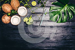 Green leaves of Monstera plant growing in wild, the tropical forest plant on black background. Lime coctail with cocktail tubes. T