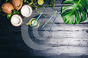 Green leaves of Monstera plant growing in wild, the tropical forest plant on black background. Lime coctail with cocktail tubes. T