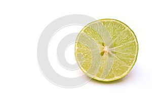green lemon, cut in half on a white background.