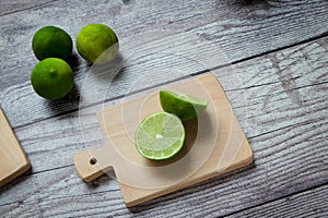 green lemons on a chopping board photo