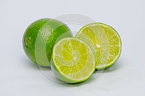 Green lemons, a lemon half cut