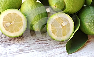 Green lemons, slices and leaves