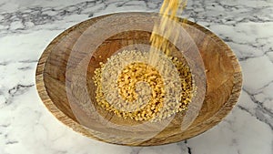 Green lentils falling in to wooden plate. slow motion