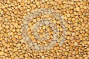 Green lentils, whole raw lens-shaped seeds, background, from above