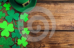 Green leprechaun hat and clover leaves on table, flat lay with space for text. St. Patrick`s Day celebration