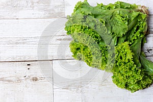 Green lettuce leaves on brown wooden overlaid background with empty space for text, template design concept, food advertising,