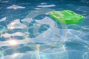 Green lifesaver floating in a swimming pool