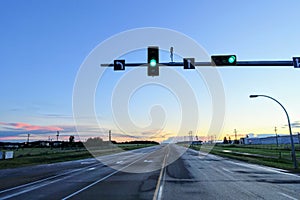 A green light at a traffic light along a highway at  dusk