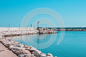 A green lighthouse on the pier of Pesaro harbor with tetrapod breakwaters Italy, Europe