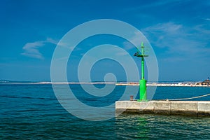 Green lighthouse under blue sky in the port of Crikvenica