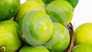 Green lime in a basket on a white wooden table
