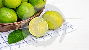 Green lime in a basket on a white wooden table