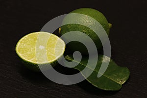 Green lime and leaf isolated on a black background