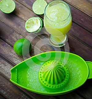 Green limes with green manual juicer on the table