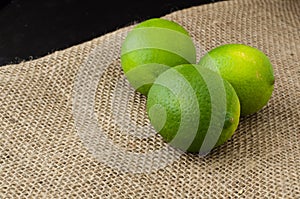 Green limes on a jute table cloth