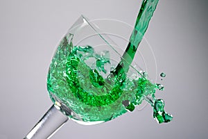 Green liquid puring in to a glass