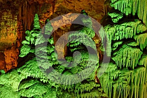 Green-lit stalagmite shapes in Soreq Cave, Israel photo