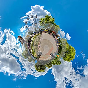 Green little planet with trees, white cluds and soft blue sky. Tiny planet of amusement park. 360 viewing angel.