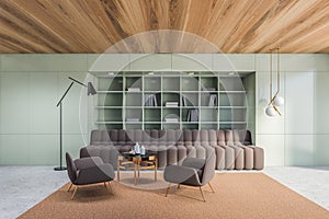 Green living room with brown bookcase and sofa