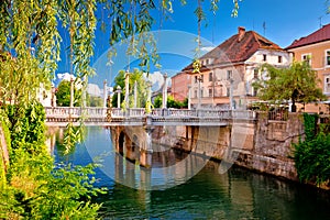 Green Ljubljanica riverfront and bridge in Ljubljana