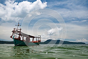 Green Longtail boat moored in Saracen Bay in Koh Ron Samloem, Cambodia