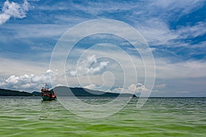 Green Longtail boat moored in Saracen Bay in Koh Ron Samloem, Cambodia