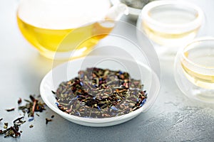 Green loose leaf tea and a teapot photo