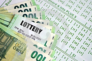 Green lottery tickets and euro money bills on blank with numbers for playing lottery