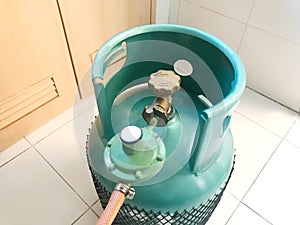 Green LPG cooking gas tank or propane tank with safety valve and photo