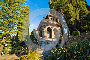 Green lush vegetation and stone pavilion in Garden of Villa Comunale also known as Parco Duca Di Cesaro, Taormina, Sicily, Italy