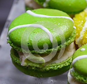 Green macarons hor` d`oeuvres filled with vanilla ice cream on crystal glass dish