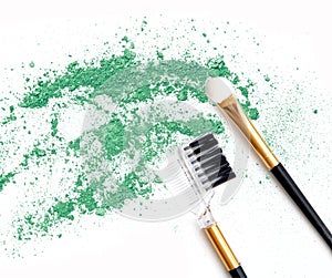 Green make up eye shadow crushed and brushes on white