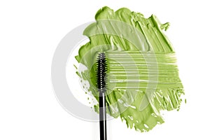 Green mascara and tassel. Textured smear. Isolated on white background.