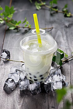 Green matcha bubble tea and black tapioca pearls on crushed ice