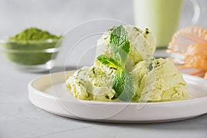 Green matcha ice cream and mint on grey table