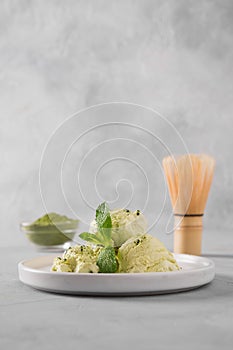 Green matcha ice cream and mint on grey table