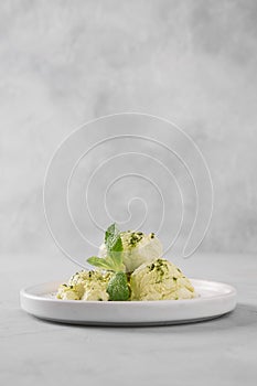 Green matcha ice cream and mint on grey table