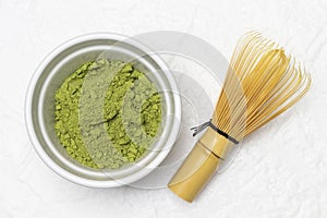 Green matcha powder in a bowl. Chasen whisk for making matcha green tea