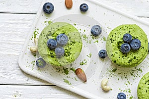 Green matcha vegan raw cakes with blueberries, mint and nuts. healthy delicious food